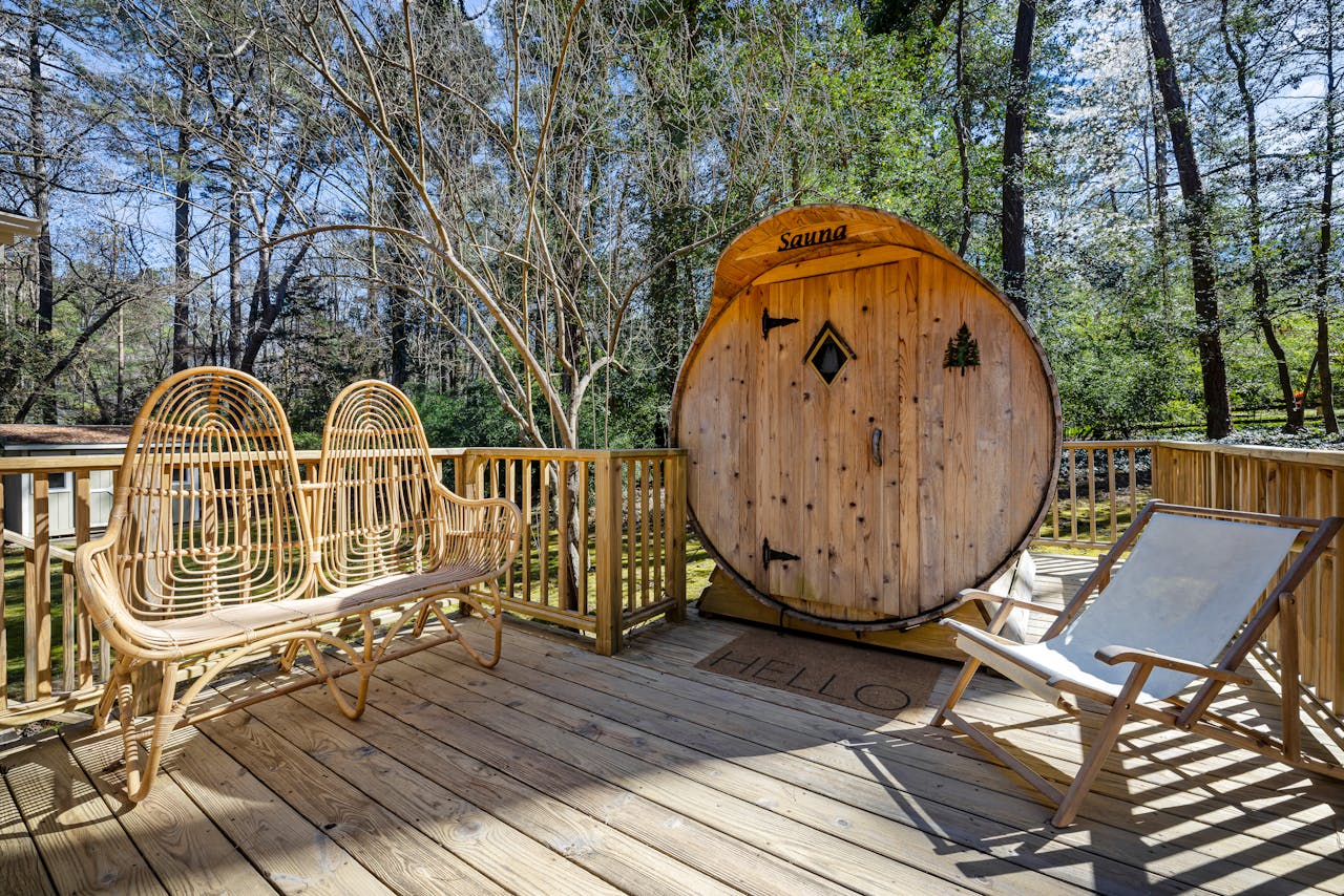 A peaceful outdoor terrace with a wooden sauna surrounded by tall trees, perfect for relaxation.